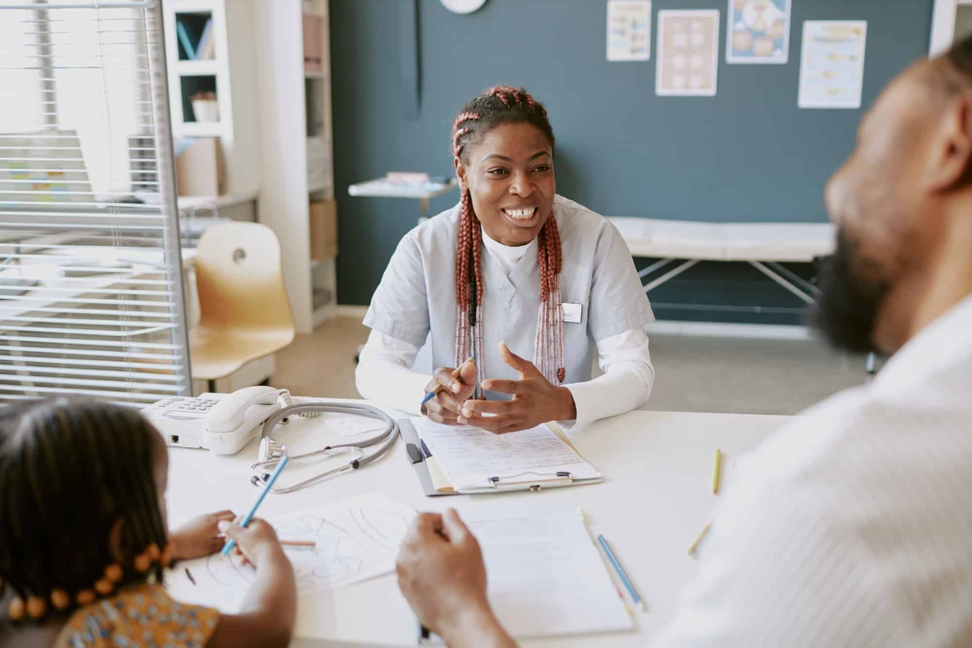 Smiling Nurse Taking Notes During Hospital Consultation